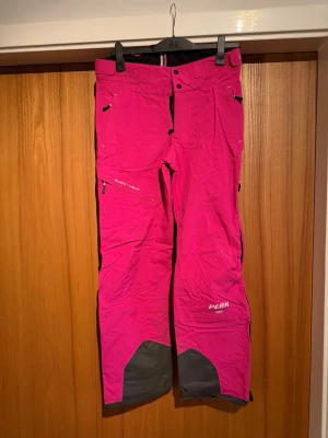 Peak Performance rosa Gore-Tex skalbyxor  M - Säljer ett par sjukt snygga rosa täckbyxor från Peak Performance, modell Black Light. Byxorna har svarta förstärkningar vid bensluten, dragkedjor på sidorna och är gjorda i slitstark Gore-Tex. Perfekta för vinter och skidåkning.