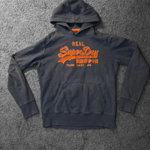 Superdry Hoodie  - Tja! Säljer en Superdry Hoodie i storleken (L) fast den sitter som en liten M. Skick 7/10. Hör av er vid minsta fundering!