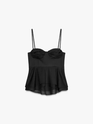 Svart korsettopp med volang - Säljer en svart korsettopp med tunna axelband och volang nedtill. Toppen har en snygg, figurnära passform och draperade kupor som ger en trendig look. Perfekt att styla med jeans eller kjol för en cool outfit.