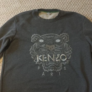 Grå Kenzo sweatshirt med tigertryck - Säljer en grå sweatshirt från Kenzo med tigertryck och loggan därframme😊