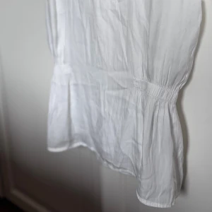 Vit topp  - Säljer en vit topp/blus från imtd med rund hals och smockad midja som ger en snygg siluett. SKRIV INNAN KÖP!