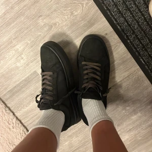 Svarta sneakers från Vagabond - Svarta sneakers från Vagabond med platt sula och rund tå. Skorna har snörning och är tillverkade i skinn med en stilren, minimalistisk look. Passar perfekt till jeans och har en klassisk streetstil. Snygga och enkla att matcha med olika outfits.