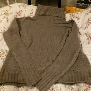 Mullvads brun polotröja från Lager 157 - Mysig brun  polotröja från Lager 157, modell HANNA. Tröjan är stickad med ribbad struktur och har lång ärm samt hög polokrage. Perfekt för att hålla värmen under kyliga dagar. Enkel och stilren design som funkar till många olika looks.