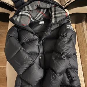 Burberry Jacka/väst - Säljer en svart Burberry jacka som går att förvandla till en väst (ärmarna går att ta av). Jackan är oanvänd - etikett och allt finns kvar. Storlek M, men passar även S och L beroende på passform.  Pris kan diskuteras..