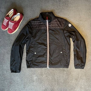 Svart vindjacka från Moncler - Tja allihopa just nu så säljer jag denna sjukt snygga svarta jacka från Moncler av modellen Portnuef Giubbotto. Storlek: 3, i eu storlek motsvarar det cirka M - Skicket på jackan är väldigt bra utan några fläckar eller skavanker Mitt pris: 2399 - Nypris: 9000kr (+). Passar perfekt på mig som är 182cm och väger 69 kg. Jag tar gärna byten om du bor i Stockholm. Artikeln är självklart autentisk. Hör av dig vid frågor eller funderingar.