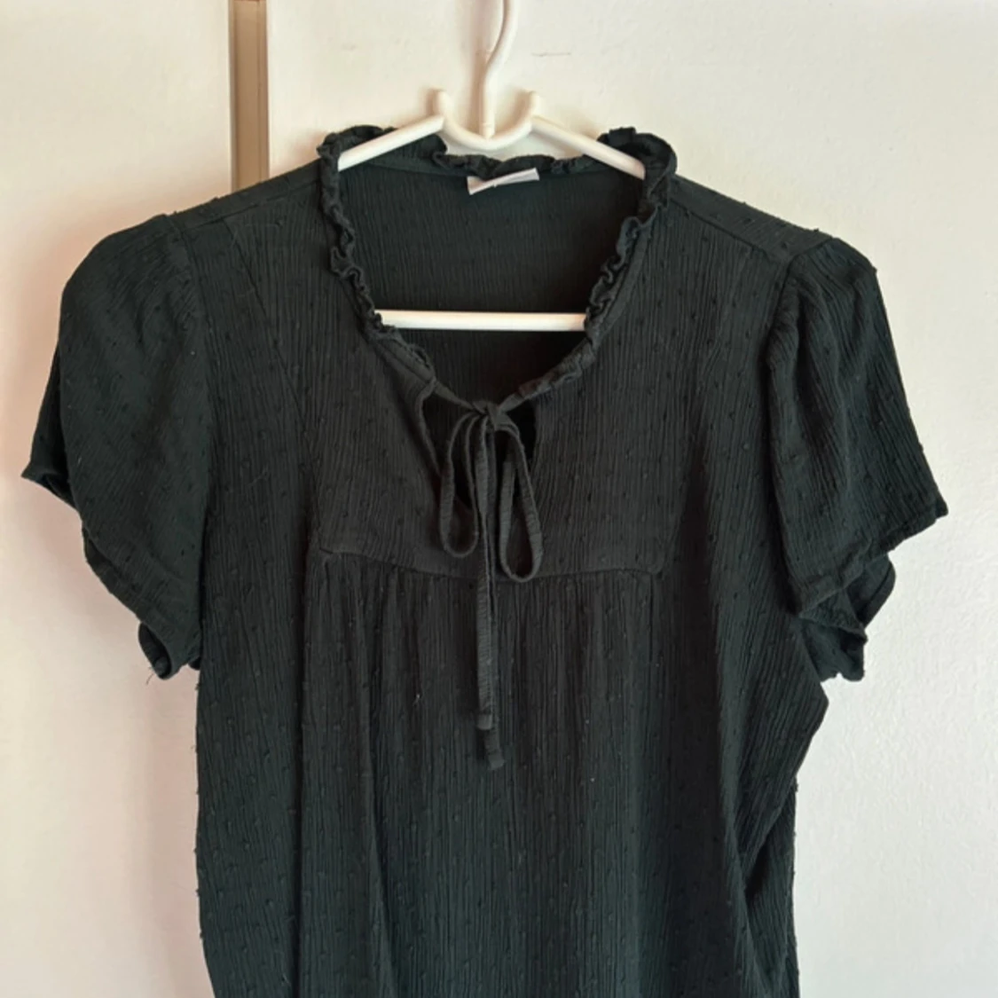 Svart blus med knyt och volang - 1