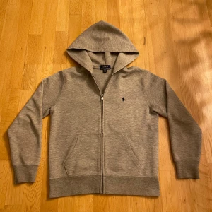 Grå hoodie från Polo Ralph Lauren -  Grå Polo Ralph Lauren Hoodie 10-12 år Ca 152