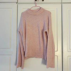 Ljusrosa stickad tröja Kappahl S🌸🌸💕 - Supermysig ljusrosa stickad tröja från Kappahl i storlek S. Tröjan har ribbade muddar vid hals, ärmslut och nederkant samt en liten slits på sidorna. Perfekt för kyliga dagar och har en loose fit med långärmade ärmar.🛍️