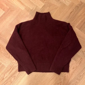 Vinröd stickad halterneck  - Mysig vinröd halterneck från Zara med ribbad hög krage och muddar. (Bara använd typ 2 ggr). Tröjan är stickad och har en loose passform som ger en chill vibe. Perfekt för kalla dagar när du vill vara både varm och snygg.