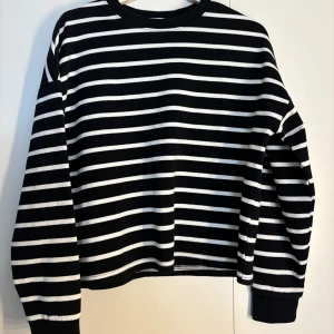 Svartvit randig långärmad tröja - Säljer en svart och vit randig långärmad tröja med klassisk rund hals från Amisu. Storlek xs men den är lite större.