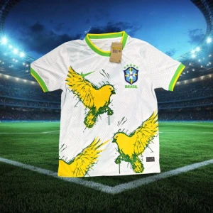 Vit Brasilien fotbollströja med fågeltryck - Snygg vit fotbollströja från Brasilien med stora gula fåglar tryckta på framsidan. Tröjan har gröna och gula detaljer vid krage och ärmslut samt Brasilien-emblem på bröstet. Perfekt för dig som vill sticka ut på läktaren eller planen.