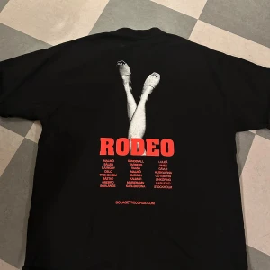 Svart RODEO t-shirt från Bolaget - Svart t-shirt med stor röd RODEO-tryck på ryggen. Endast använd 1 gång, mycket fint skick. Pris kan absolut diskuteras vid snabb affär 🥰