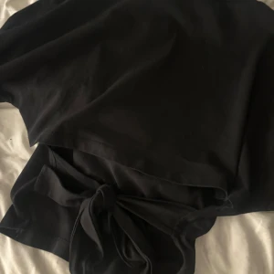 Open back tie tee - T-shirt med knytning i ryggen från Nelly! Säljer eftersom den inte används. Endast använd ett fåtal gånger så har inga tecken på användning. 