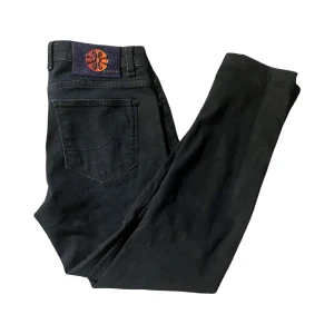 Svarta jeans från Jacob Cohën Limited Edition - Snygga svarta jeans från Jacob Cohën Limited Edition med exklusiv patch i lila, rött och orange på bakfickan. Klassisk femficksmodell med raka ben och diskreta sömmar. Tillverkade i mjukt jeanstyg med lyxig känsla och unika detaljer. Modell 688C