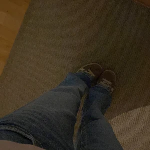 Blå bootcut jeans med låg midja - Säljer ett par ljusblå bootcut jeans med snygg tvätt och klassiska fem fickor. Jeansen har låg midja och är tillverkade i mjukt denimtyg som sitter skönt. Perfekta för dig som gillar en avslappnad och trendig look.
