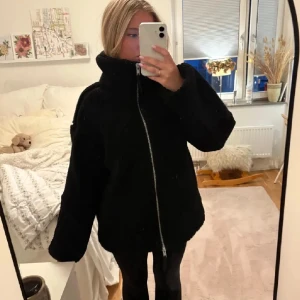Svart oversized teddyjacka med dragkedja - Mysig svart teddyjacka från HM, endast använt några fåtal gånger. Super mysig och perfekt till hösten/vintern! Kom gärna med prisförslag!