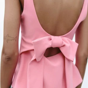 Rosa topp med Rosett - Supersöt rosa topp med ett rosett på ryggen. Har bara använt den 1 gång och är därför i jättebra skick!!🩷