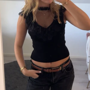 Svart spetsblus med mesh och volang - Svart topp i storlek xs!