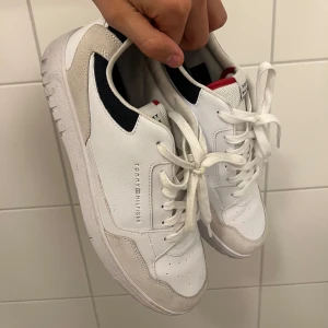 Tommy Hilfiger skor - Snygga vita sneakers från Tommy Hilfiger. Använda fåtal gånger så fortfarande i toppskick. Nypris runt 1000kr. Box ingår. Skriv om frågor eller funderingar!