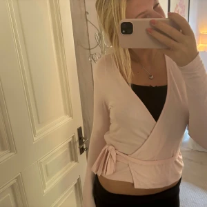 Oöppnad och ny ljusrosa kofta med knytband - Supersöt ljusrosa omlottkofta med knytband i midjan och lång ärm. Helt ny och oöppnad!' Fråga om mer bilder om det behövs!