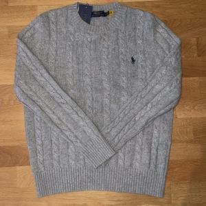Ralph Lauren Cableknit - Säljer en stickad Ralph Lauren cableknit i storlek S, aldrig använd och i nyskick. Hör av dig vid minsta fundering!