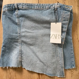 Assymetrisk topp - Helt oanvänd korsett-topp i jeansmaterial. Strl. M men ganska liten i storleken.