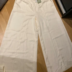 Vida vita byxor - Snygga och luftiga vita byxor med breda ben och resår i midjan. Helt nya med prislapp på. 