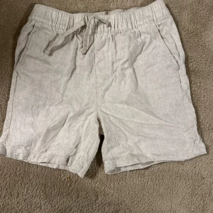  Linneshorts från ONLY - Snygga beiga shorts från ONLY i linne med elastisk midja och snörning framtill. De har sidfickor och en bakficka, perfekt för varma dagar. Lätta och luftiga med avslappnad passform. Den är en 146 men den passar en 160 bättre!