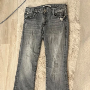 Grå jeans Bella Mid-Rise 29/30 - Grå jeans från Zalando, modell Bella Mid-Rise. Byxorna har en klassisk femficksdesign, slitna detaljer vid fickorna och raka ben. Jeansen är i mjuk bomullsdenim och har en snygg tvättad look som passar till det mesta. (Inköpt för 749kr)