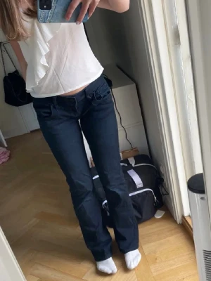 Mörkblå bootcut jeans låg midja - Säljer ett par mörkblå jeans med bootcut passform och låg midja från Ltb. Jeansen har klassisk femficksdesign och är tillverkade i ett stretchigt jeansmaterial som sitter snyggt på benen.  Midjemått:39 innebenslängd: ca85