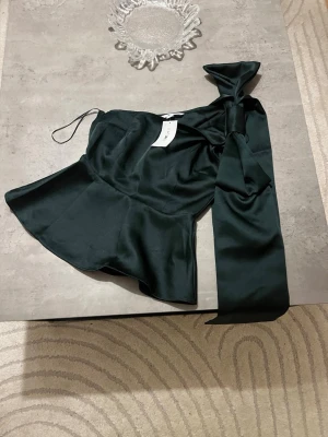 One Shoulder Topp Med Rosett  - Mörkgrön topp från h&m i stl xs, helt slutsåld i den stl. Oanvänd med lapp kvar.