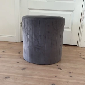 Grå sammetpall från MIO  - Säljer min super mysiga pall från MIO i sammetmaterial. Super skön att sitta på med en perfekt höjd för sminkbord eller annat tillbehör. Lite små trasig på sidorna inuti pallen. 💓Hör bara av er om frågor eller annat går endast att hämta upp eller lämnas av utanför hemmet✨🌸