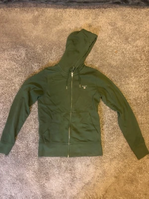 Gant hoodie - Säljer en gant hoodie i färgen mörkgrön! Den gröna färgen gör så att du sticker ut lite gran men ser riktigt stilig ut! 