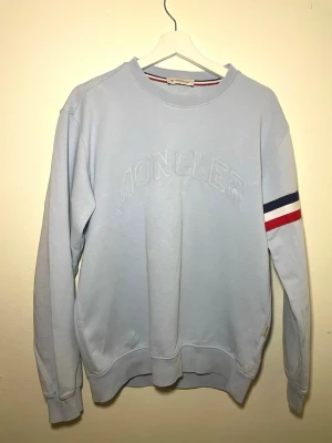 Ljusblå Moncler sweatshirt  - Ljusblå Moncler sweatshirt för herr. Stilren och modern modell som funkar perfekt till vardag och streetwear. Mjuk och bekväm med fin passform. Bra skick utan anmärkningar. Skickas snabbt !
