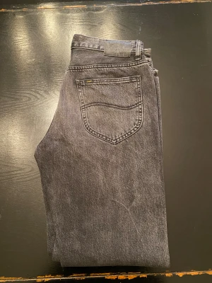 Lee svarta straight jeans - Säljer ett par svarta Lee jeans . Jeansen har en mörk tvätt och är tillverkade i slitstarkt denimtyg. Storlek W31 L34.