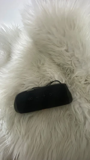JBL Flip 4 Bluetooth-högtalare - JBL Flip 4 är en portabel Bluetooth-högtalare med kraftfullt ljud och robust design. Perfekt för både inomhus- och utomhusbruk. Högtalaren ser ut att vara i gott skick utan synliga skador eller större slitage. Enkel att ta med tack vare kompakt format och praktisk rem. Den är vattentät och håller jätte länge. Batteriet / laddet  är jätte bra och håller i upp til mer än en vecka 