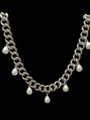 Chunky halsband i stål med pärlor - Säljer ett chunky halsband i rostfritt stål med breda länkar och hängande droppformade pärlor. Halsbandet är silverfärgat och ger en cool statement-look. Perfekt accessoar för att lyfta vilken outfit som helst.