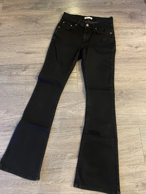 Svarta bootcut jeans från Perfect Jeans - Säljer ett par svarta bootcut jeans från Perfect Jeans i storlek 36. De har klassisk femficksdesign, silverfärgad knapp och svarta sömmar. Jeansen är i stretchigt material och har en snygg utsvängd passform nertill.
