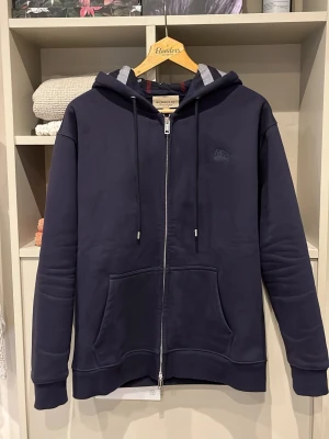 Navy Burberry Zip - Säljer denna riktigt fina o sällsynta ziphoodien från Burberry | Storlek S | Mått📏: ca 69 längd o 46 axel till axel | Tröjan är dubbeldragkedjad där det står ”burberry” på | Vid fler frågor hör gärna av er!🏌️