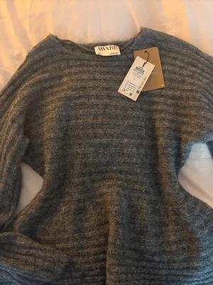 Grå stickad tröja från AWARE - Mysig grå stickad tröja från AWARE i storlek S. Går in lite i midjan. Köpte och ångrade mig, prislapp sitter kvar och tröjan är helt oanvänd. 💞