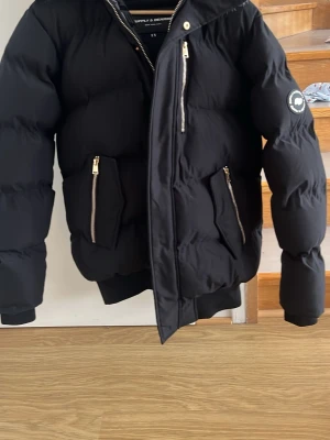  purpose: Svart pufferjacka Supply & Demand XS - Säljer en svart pufferjacka från Supply & Demand i storlek XS. Jackan har guldfärgade dragkedjor, huva med avtagbar fuskpäls. Den är i nyskick endast använd ett fåtal gånger och kvitto finns! Nypris 1400 mitt pris 600. Hör gärna av er vid intresse😃