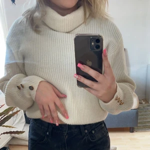  Vit stickad tröja  -  Vit stickad tröja med guld detaljer på armen. Storlek 34-36