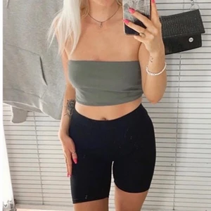 Grön tubtopp - Grön tubtopp från Gina. Som du ser på bilden så har den små defekter men som man snabbt kan lösa med nål och tråd eller låta va då det ej syns vid användning! Annars väldigt skönt material och skulle inte sälja om jag fortfarande kunnat ha på mig den! 