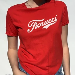 Vintage Fiorucci logo t-shirt röd stolek small  - Intresse koll! Cutest Fiorucci t-shirt med den klassiska coca-cola logga stil i vitt. Super 90s och y2k vibe . Passar xs-medium. Längd på t-shirt 53cm. Skriv gärna om ni är intresserade. 