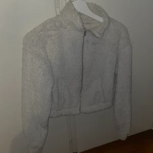 Fluffig croptop  - Fluffig, vit croptop från Nelly. Storlek 36, kan skickas spårbart!