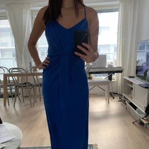 Kornblå långklänning - Använd en gång på en bal. Tvättad en gång så materialet är något nopprig men inget som man tänker på. Snygg rygg! Från Nelly med märket estradeur.