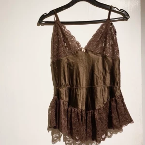 Brunt linne i silke och spets  - Säljer världens finaste bruna linne. Älskar detta men det är tyvärr lite litet runt brösten så väljer att sälja😭 det kan passa många olik storlekar beroende på hur stora bröst man har. Men skulle säga att det passar en S-L så länge man inte har större än en C-D kupa❤️ det är vintage HM en väldigt gammal modell <3 budgivning! 