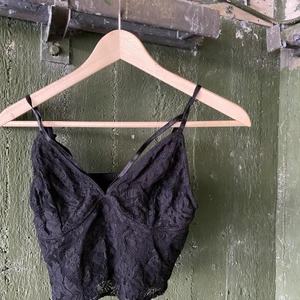 Linne från bikbok  - Säljer mitt supersöta spets linne från bikbok i storlek M. De är två band som ligger över bysten som man ser på bilden 🖤 Jätte fint att ha under en kavaj i sommar och den är i väldigt bra skick då jag använt de sparsamt 🌻