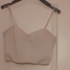 Topp - En söt vit copad topp från bikbok e stretchar i ryggen, köparen står för frakten