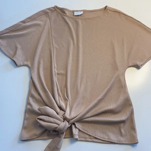 Blus/t-shirt - En fin blus i typ stickat tyg med Knut på sidan, beige. Nästan oanvänd. 